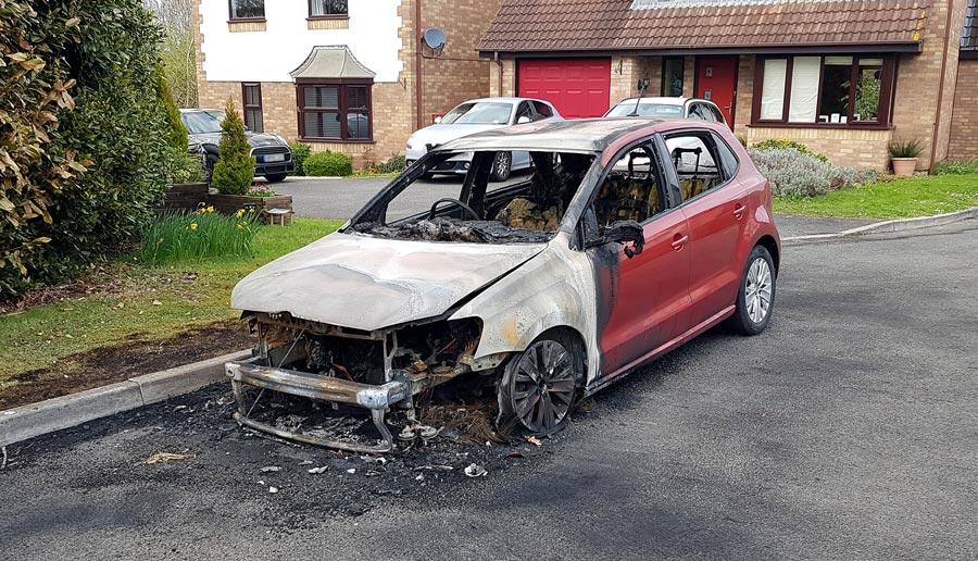 Photo of a burnt-out car.