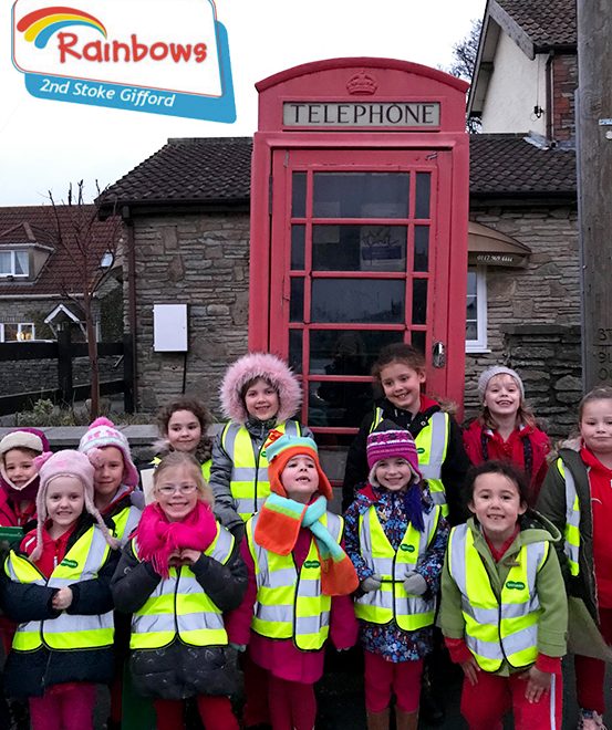 Photo of girls from the 2nd Stoke Gifford Rainbows gathered outside the disused telephone box.