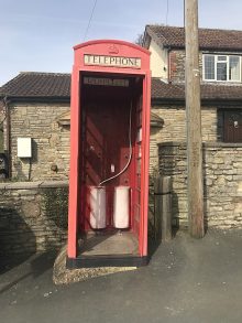 The telephone box without its door, which has been removed for repair.
