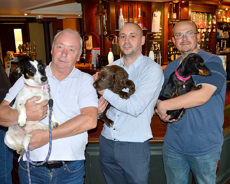Photo of three dog owners standing in front of the bar and holding their pets in the Beaufort Arms, Stoke Gifford.