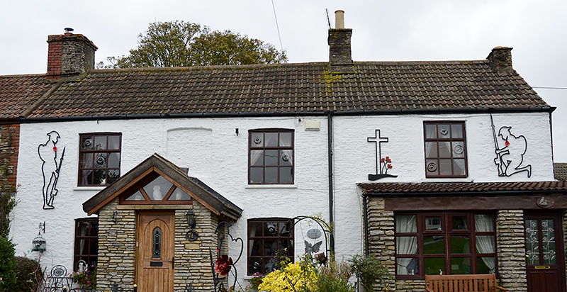 Photo of Tommy silhouettes on the walls of two adjacent cottages.