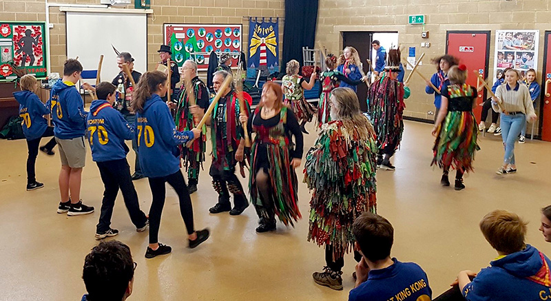 Photo of Scouts being taught morris dancing by a visiting side.