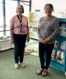 Photo of volunteers Merle Bathe-Taylor and Janet Bacon in the library.