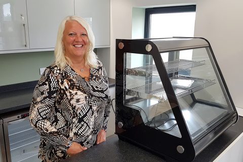 Photo of Hayley Mannion standing at the counter of the new Little Stoke Community Café.