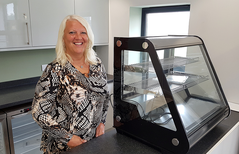 Photo of Hayley Mannion standing at the counter of the new Little Stoke Community Café.