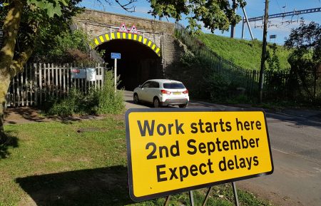 Photo of a 'Work starting here soon' sign at the railway bridge.