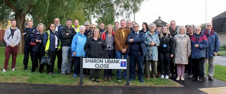 A crowd gathered around the road sign for Sharon Ubnak Close at the official opening.