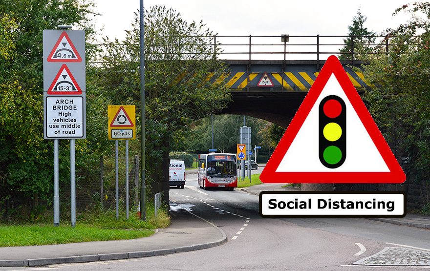 Photo of a traffic lights sign with the text 'social distancing' beneath, superimposed on an image of the railway bridge.