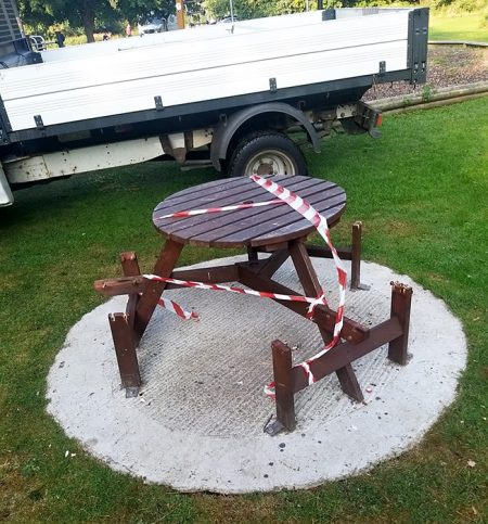 Photo of a vandalised picnic table and bench.