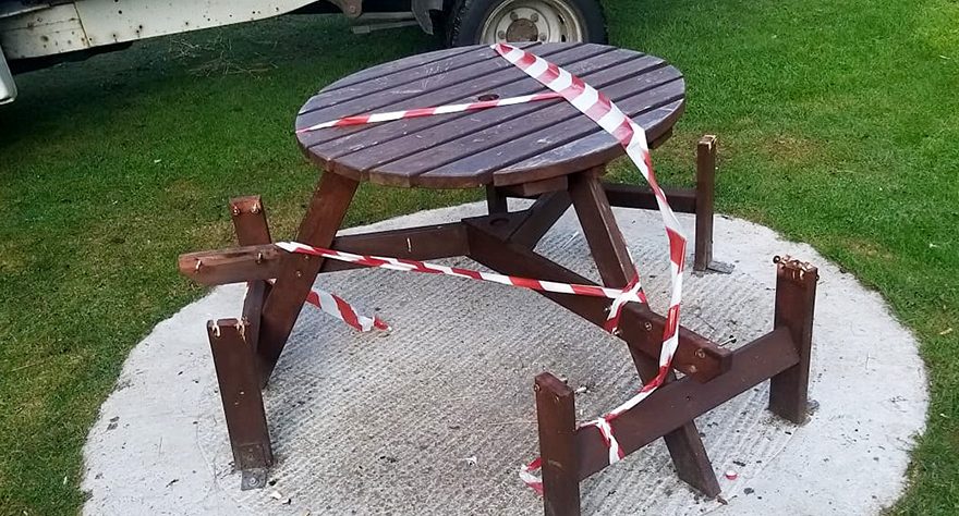 Photo of a vandalised picnic table and bench.