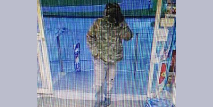 CCTV image showing a masked person entering the store.