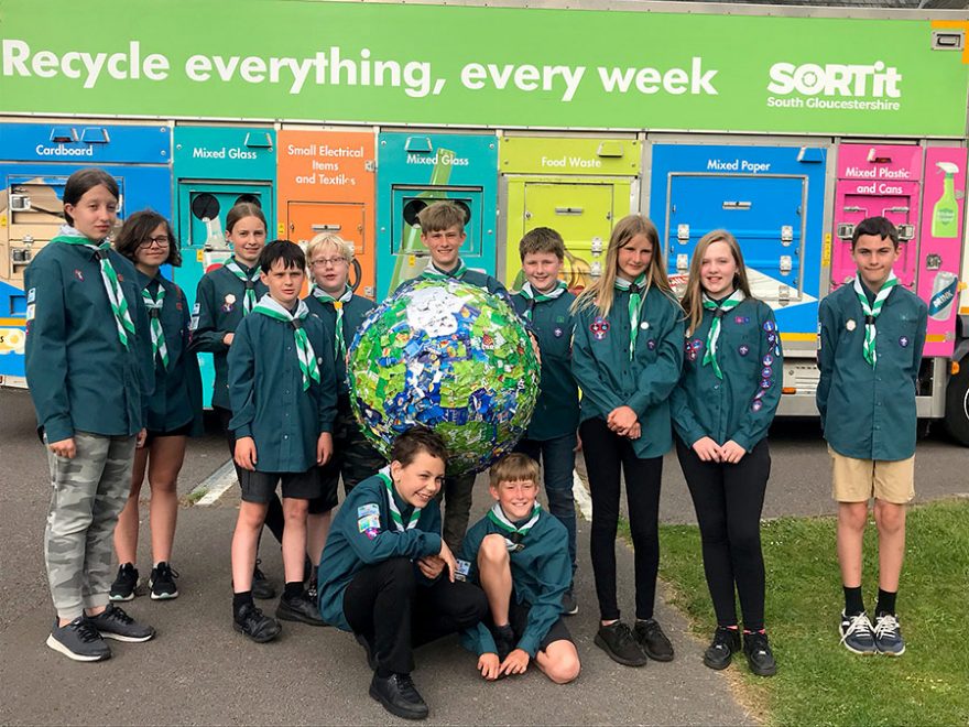 A group of Scouts standing in front of a recycling collection truck.