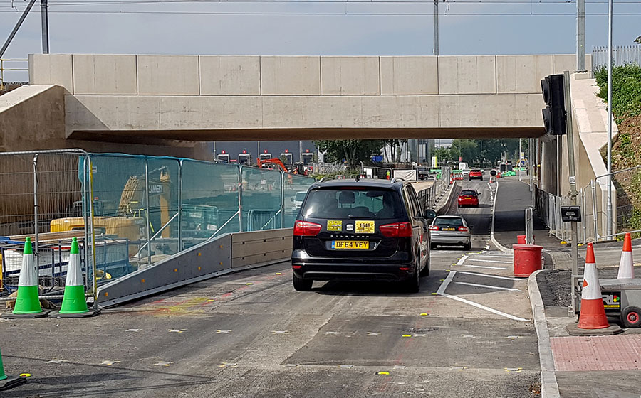 Photo of cars passing under a bridge.