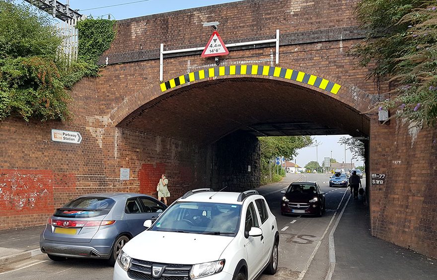 Photo of traffic passing under a railway bridge.