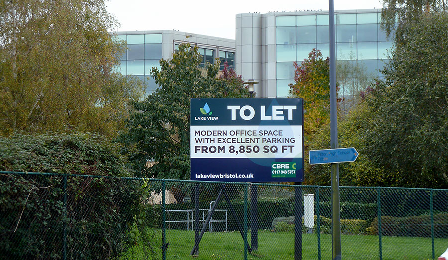 Photo of a 'To let' sign in front of an office block.