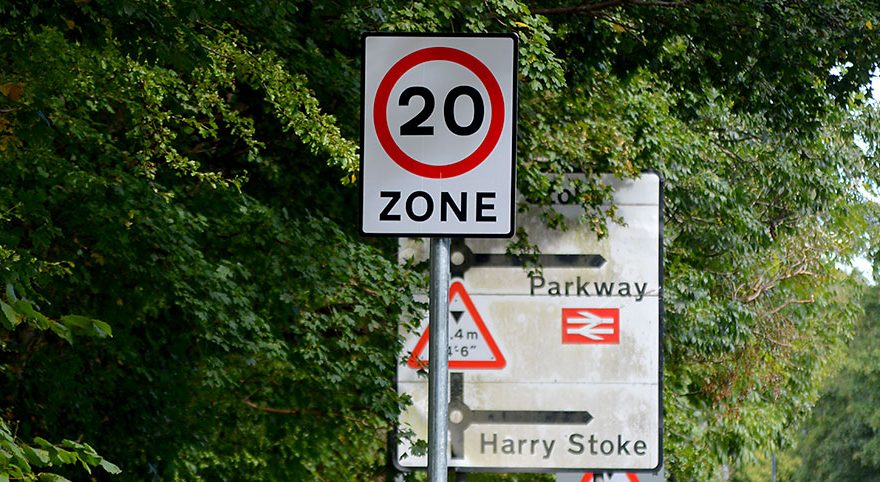 Photo of a 20mph road sign, amongst other signs.