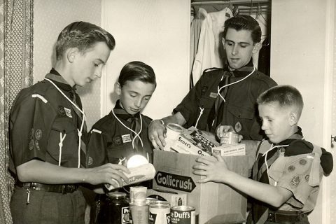 Photo of a group of scouts packing provisions into a cardboard box.