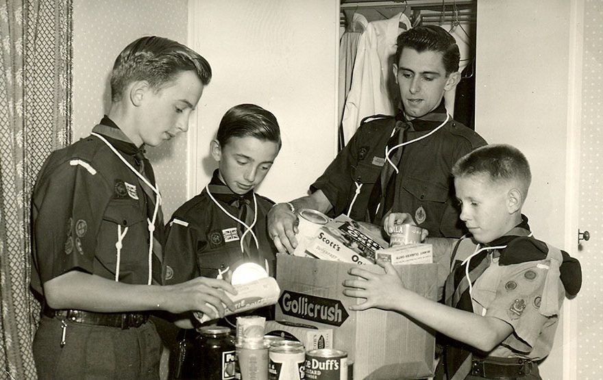 Photo of a group of scouts packing provisions into a cardboard box.