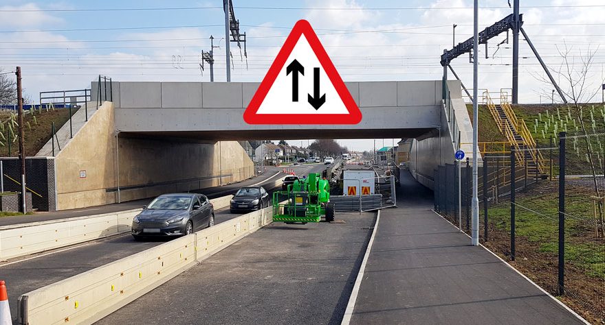 Photo of a railway bridge with single file traffic passing beneath it.