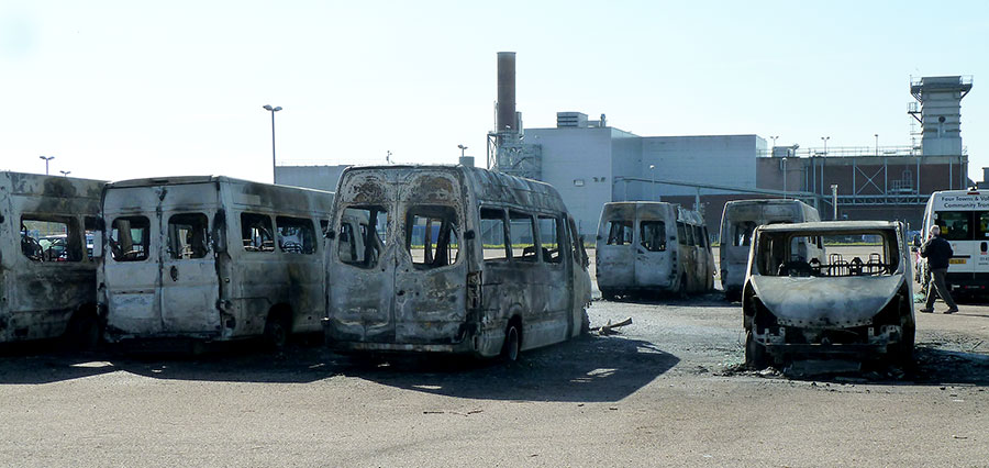 Photo of several fire-damaged minibuses.