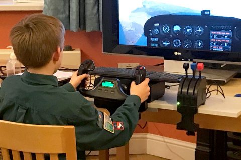 Photo of a Scout using a desktop flight simulator.