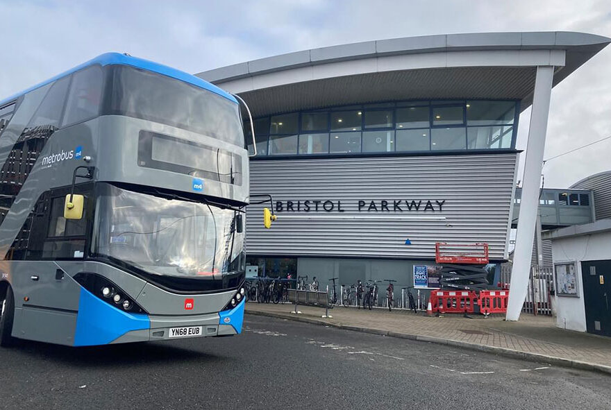 Photo of a double decker bus outside a railway station.