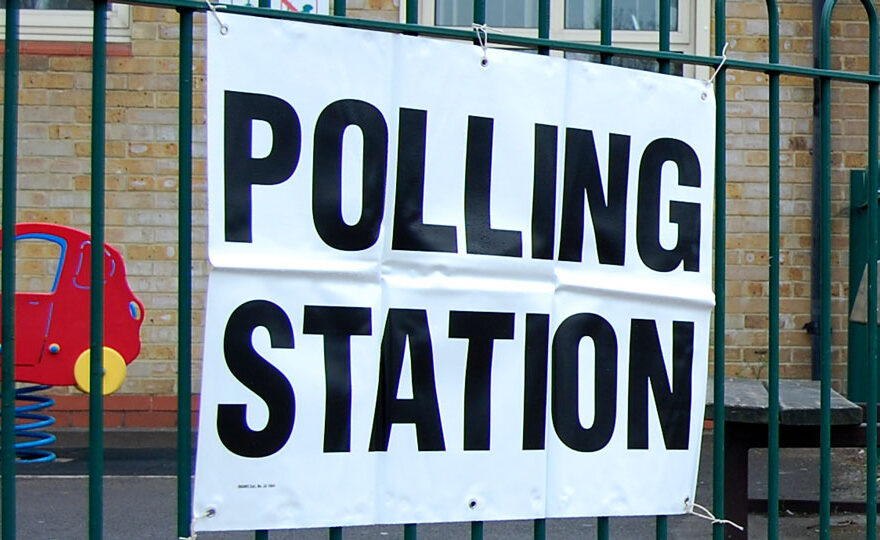 Photo of a sign displaying the words 'polling station'.