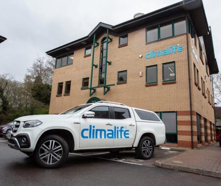 Photo of a white car in front of a building.